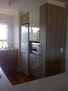 cocina con nevera y fregadero en Beachfront Apartment at Seaspray in Blouberg, en Bloubergstrand