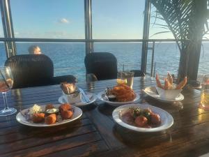 a table with plates of food on it with the ocean in the background at Vero House TERRAZA DE LA PAZ in San Miguel de Abona