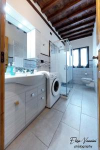 y baño con lavadora y lavamanos. en Appartamento Sole-Luna, en Colleoli