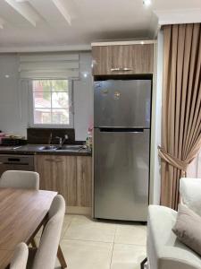uma cozinha com um frigorífico de aço inoxidável e uma mesa em Villa soso em Okurcalar