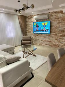 ein Wohnzimmer mit einem TV an einer Backsteinwand in der Unterkunft Villa soso in Okurcalar
