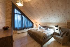 sypialnia z łóżkiem i drewnianym sufitem w obiekcie Vila Lomnica Vysoké Tatry w Wielkiej Łomnicy