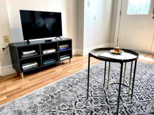 a living room with a table and a television at Great Apartment in WeHo in Nashville
