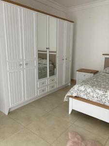 1 dormitorio con armarios blancos y 1 cama en Villa soso en Okurcalar