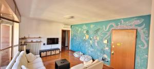 una sala de estar con una gran pintura en la pared en Spacious bright apartment near city center and Como lake with air conditioning, en Lecco