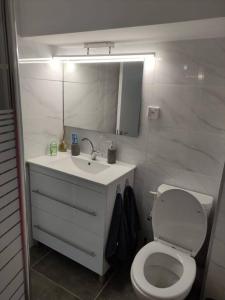een badkamer met een toilet, een wastafel en een spiegel bij יחידת אירוח חדשה ומקסימה בכרמיאל in Karmiël