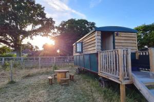 a tiny house with a porch and a table at Penelope in West Chiltington