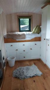 a small bedroom with a bed and a window at Penelope in West Chiltington