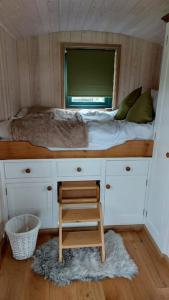 a small bedroom with a bed and a chair in it at Penelope in West Chiltington