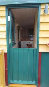 a green door of a house with a kitchen in it at Penelope in West Chiltington +7 photos
