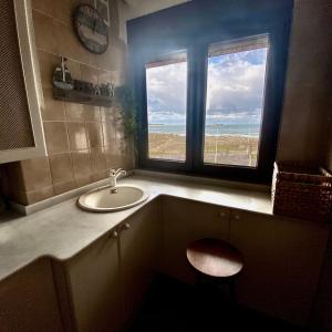 uma casa de banho com um lavatório e uma janela em Vistas al Mar em Somo