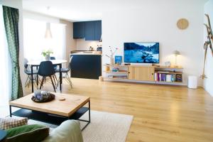 a living room with a couch and a table and a kitchen at Sonnige Panorama Aussicht bei Davos Lenzerheide in Schmitten