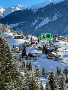 a small town in the mountains with snow on the ground at Sonnige Panorama Aussicht bei Davos Lenzerheide in Schmitten