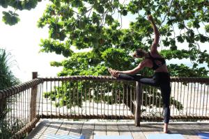 a woman doing a yoga pose on a fence at Kitu Kiblu in Baleni