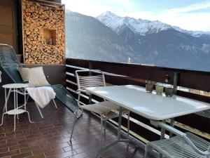 a table and chairs on a balcony with mountains at Sonnige Panorama Aussicht bei Davos Lenzerheide in Schmitten