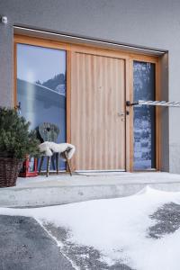 una puerta delantera de una casa con una silla en la parte delantera en Haus Sonnblick b&b en Stuben am Arlberg