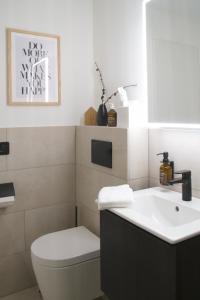a bathroom with a white toilet and a sink at Sonnige Panorama Aussicht bei Davos Lenzerheide in Schmitten