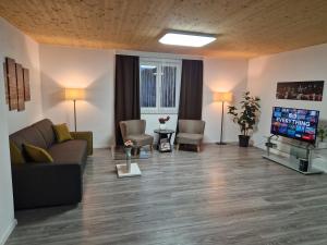 a living room with a couch and a flat screen tv at Apartment St. Pölten in Sankt Pölten