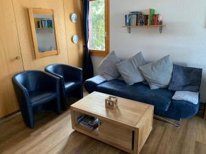 uma sala de estar com um sofá azul e uma mesa de centro em Chrinnengletscher em Grindelwald