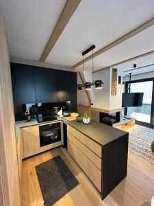 a kitchen with black cabinets and a black counter top at Ski & Relax Apartment Bjelašnica in Bjelašnica