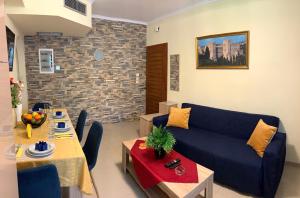 uma sala de estar com um sofá azul e uma mesa em A&B Rhodes city apartments in Ilha de Rhodes