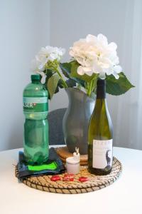 a table with two bottles of wine and a vase with flowers at Sonnige Panorama Aussicht bei Davos Lenzerheide in Schmitten