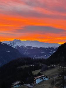 a sunset in the mountains with a snow covered mountain at Sonnige Panorama Aussicht bei Davos Lenzerheide in Schmitten