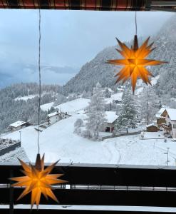 two autumn leaves are hanging from a window at Sonnige Panorama Aussicht bei Davos Lenzerheide in Schmitten