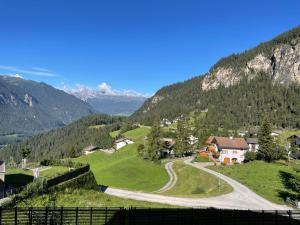 a winding road in a village in the mountains at Sonnige Panorama Aussicht bei Davos Lenzerheide in Schmitten