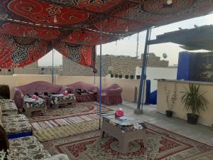 a living room with couches and tables under a tent at Grand Hotel &Hostel in Luxor