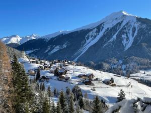 a small village in the snow with a mountain at Sonnige Panorama Aussicht bei Davos Lenzerheide in Schmitten