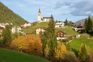 a small village with a church on a hill at Sonnige Panorama Aussicht bei Davos Lenzerheide in Schmitten