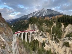 a train on a bridge over a mountain at Sonnige Panorama Aussicht bei Davos Lenzerheide in Schmitten