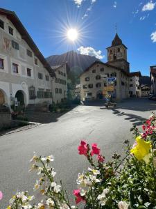 a street in a village with a church and flowers at Sonnige Panorama Aussicht bei Davos Lenzerheide in Schmitten