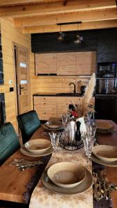 a wooden table with plates and wine glasses on it at Hamajdówka in Zubrzyca Górna