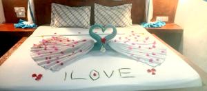 a bed with two hearts and the words i love at Kiungani Lodge in Jambiani