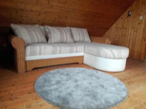 a living room with a white couch and a blue rug at VÁRBALOG in Várbalog
