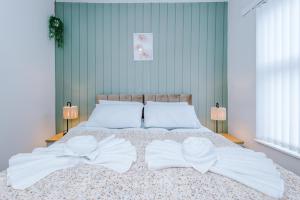 a bedroom with a bed with two white bows on it at Trendy house, close to stadiums, free wifi and car park in Liverpool +27 photos