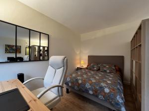 - une chambre avec un lit, un bureau et une table dans l'établissement Spacieux studio sur jardin, beaucoup de charme, à Boulogne-Billancourt