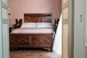 una camera con un grande letto con testiera in legno di Puleera a San Leonardello