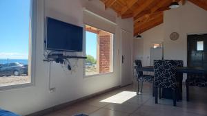 a living room with a flat screen tv on a wall at Casa costanera Lago Buenos Aires, Los Antiguos in Los Antiguos