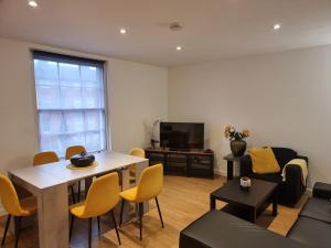 a living room with a table and yellow chairs at Heritage Place by Select SA in Reading