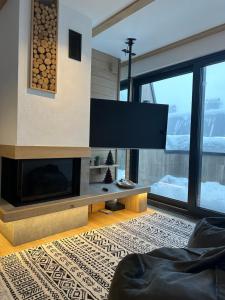 a living room with a fireplace and a tv at Ski & Relax Apartment Bjelašnica in Bjelašnica