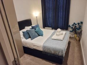 a small bedroom with a bed with blue pillows at Heritage Place by Select SA in Reading