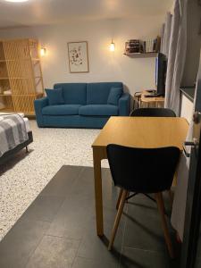 a living room with a blue couch and a table at Sólheimar Studio Apartment in Ísafjörður