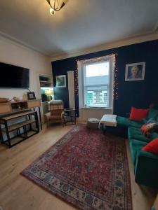 a living room with a green couch and a rug at Lovely 2 bedroom apartment in Fife in Fife