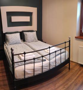 a bedroom with a black bed with white sheets and pillows at Apartament Visit Ustroń in Ustroń