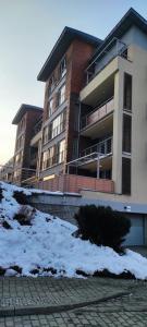 a apartment building with snow in front of it at Apartament Visit Ustroń in Ustroń