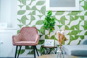 a living room with a pink chair and a plant at Trendy house, close to stadiums, free wifi and car park in Liverpool