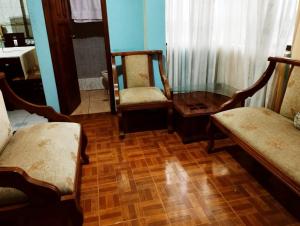 sala de estar con 2 sillas y mesa en Bonito Departamento Sur de Quito, en Quito